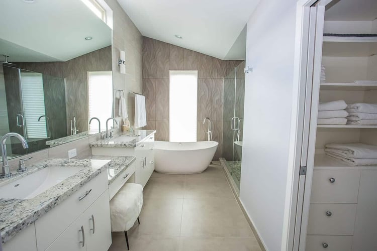 All Star Construction bathroom renovation on Cindy Lane in Houston with a freestanding tub, glass shower, and granite vanities.