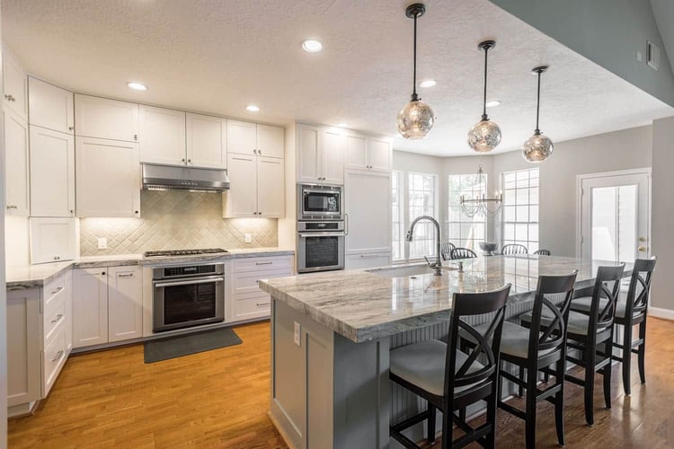 All Star Construction kitchen renovation on Greenrush Drive in Houston with white cabinetry, granite island, and pendant lighting.