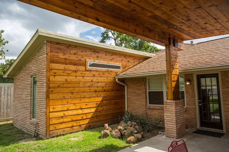 A remodeled covered patio connected to a Houston, Texas, home with concrete flooring and treated wood ceiling